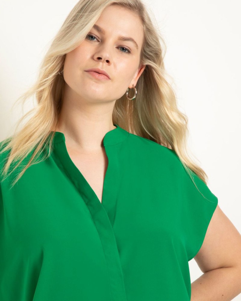 Front of a model wearing a size 16 Notch Collar Blouse in Jelly Bean by ELOQUII. | dia_product_style_image_id:309950
